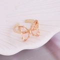 Macro detail of adjustable golden butterfly ring with transparent pink crystal - One Size / Peach