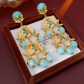 Details von Vintage-Ohrringen in Blumenform aus Gold mit blauen Perlen in einer Box - 1# Cyan Vintage Quasten Ohrclips (HE12368)