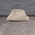 Detail shot showing the woven texture and pleated design of the beige knitted clutch bag - White
