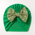 Detail of baby turban hat featuring a large gold polka dot olive green bow on soft fabric - Green