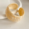 Close-up of cream marble textured acetate open bracelet in a minimalist jewelry display - Cream Marble