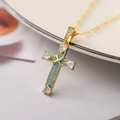 Macro di un ciondolo a croce placcato oro 18K con turchese e cristalli a forma di cuore - Turchese