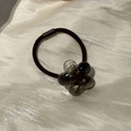 Elastisches Haargummi mit braunem, transparentem Blumenanhänger auf weichem Stoff - Teefarbene Blume Schwarzes Haargummi