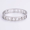 Detalle de letras LOVE plateadas y cierre geométrico con diamantes en brazalete de acero - Color Acero
