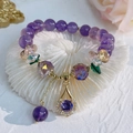Detailopname van paarse amethist armband met gouden accenten op witte koraalsteen - Amethist Waterdruppel