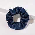 Dettaglio di un elastico in raso blu scuro con texture setosa su base bianca - Blu navy