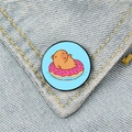 Süße Capybara-Emaille-Anstecknadel auf rosa Donut-Schwimmreifen an einer Jeansjacke - Donut-Schwimmer Wasserschwein