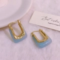 U-shaped gold-plated earrings with light blue marble resin insets on white plush background - 18K Gold / Light Blue