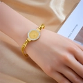 Bracelet rétro avec pièce dorée et zircons posé sur fond de soie champagne - Style Pièce Portrait (B984)