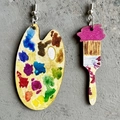 Künstlerische Holzohrringe mit Farbpalette und Pinsel-Design auf Betonhintergrund - Palette und Pinsel