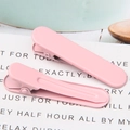 Close-up of pink macabre metal duckbill hair clips with a smooth matte finish on white card - 1.3x4.9cm / Pink