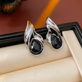 Gros plan de boucles d'oreilles argentées en forme de larme noire dans leur écrin - Tige en Argent S925 (WE4292) / Noir
