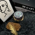 Aromatic soy candle in a teal mandala floral tin box placed on a soft grey plush rug - H18 Mint