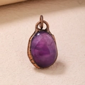 Vintage bronze pendant featuring a smooth oval purple amethyst stone with antique textures - Purple Crystal