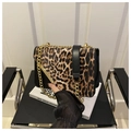 Detail van luipaardprint crossbodytas met gouden ketting en magnetische sluiting - Zwart