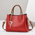 Red textured leather tote bag with brown handles and a gold moon pearl pendant charm - Burgundy