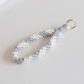 Close-up of handmade gray and white woven cotton wristlet strap with gold metal clasp - Grey and White