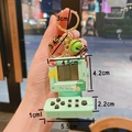 Details des mintgrünen Retro-Arcade-Schlüsselanhängers mit Hello Dino-Grafik und Maßen - Dinosaurier-Thema / Grün