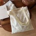 Macro shot of cream lace embroidery details and fabric label on a vintage tote bag - Organza Paisley