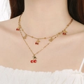Double-layered gold stainless steel necklace with red cherry pendants worn by a model - Multiple Cherry Pendants Style (KN295003-SXSJ)