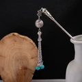 Detail of silver hair stick with turquoise beads and metallic tassels in a vase - Silver/F320/Turquoise Bead Tassel