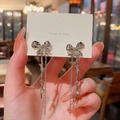 Detail of silver bow tassel earrings featuring dangling chains and zircon accents - A1239 Silver