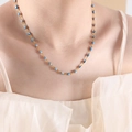 Golden titanium necklace featuring blue and white evil eye beads worn by a model - Blue Necklace