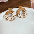 Dettaglio di orecchini bohémien con cerchi in rattan marrone e conchiglie su un piatto - 13# Perno per orecchini in argento-Caffè-Bianco-Tondo (Cornice tonda in rattan con conchiglie bianche)