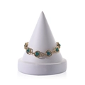 Golden heart-link bracelet with green gemstones displayed on a white jewelry stand - White
