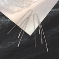Elegant silver long tassel ear threads with faceted cylindrical charms on white paper - Cylinder Tassel Ear Threader