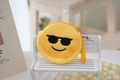 Detail showing a round yellow plush emoji purse with sunglasses on a white mini wooden bench - Style 3 (Sunglasses)