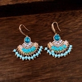 Dettaglio macro di orecchini vintage con perle turchesi e finiture in metallo dorato - Oro-Blu