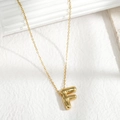 Minimalist golden necklace with a 3D chubby letter F pendant on white background - Letter F