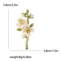 Broche de rama de ciruelo con flores blancas y perlas sobre fondo blanco neutro - Verde
