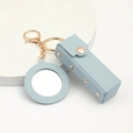 Detail of light blue PU leather lipstick case keychain with mirror and golden hardware - Blue