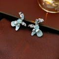 Macro shot of silver bow earrings with light blue petals and sparkling zircon details - Silver Earring Post-Green