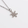 Collier avec pendentif flocon de neige de Noël en acier inoxydable sur fond blanc pur - Pendentif Flocon de Neige Évidé Exquis / Argenté