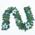 Lush green Christmas garland decorated with festive blue poinsettias and matching blue baubles - Blue Decorated Garland