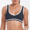Detail eines schwarzen Sport-BHs mit weißen Kontrastpaspeln und hochelastischem Stoff - S / Schwarz