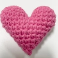 Handmade pink crochet heart charm accessory with tight knit texture on white background - Rose Red Heart