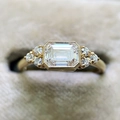 Vista macro de anillo con diamante de talla esmeralda y detalles milgrain en terciopelo - US 6 / Dorado