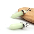 Detail of light green hexagonal crystal point pendants with silver metal bails on wood - Luminous Green Blue