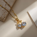 Macro detail of cherry pendant with clear round crystals and golden bow tie link - Gold Cherry