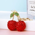 Sparkly red rhinestone cherry keychain with green leaves on a gold metal link chain - Red