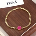 Pulsera de cuentas doradas con colgante redondo de esmalte rosa sobre madera - Rosa Rojo