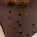 Detail of stainless steel tag on bohemian black beaded flower necklace and bracelet set - Black Necklace And Bracelet