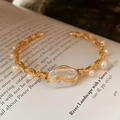 Macro shot of baroque pearl cuff bracelet with gold wire wrapping on vintage paper background - 1# Cuff - Freshwater Pearl