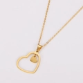Detalle de los colgantes de corazón hueco dorado y corazón sólido en cadena de metal - Dorado