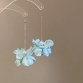 Détail de boucles d'oreilles fleur en tissu bleu avec perles et longues franges dorées - Bleu