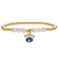 Goldenes Perlenarmband mit weißen Perlen und einem blauen Evil-Eye-Anhänger auf Weiß - Blau-grüner Böser Blick Stil